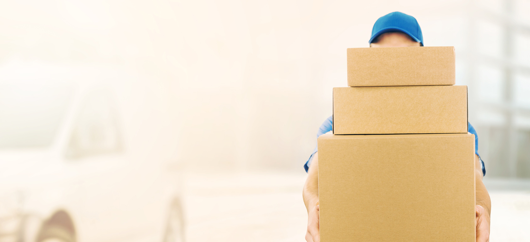 delivery man holding pile of cardboard boxes in front. copy space